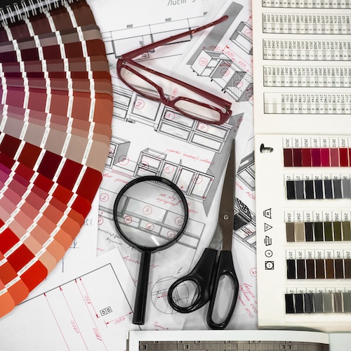 Architectural blueprint interior with wooden and paper samples and a multi-colored palette and draw tools